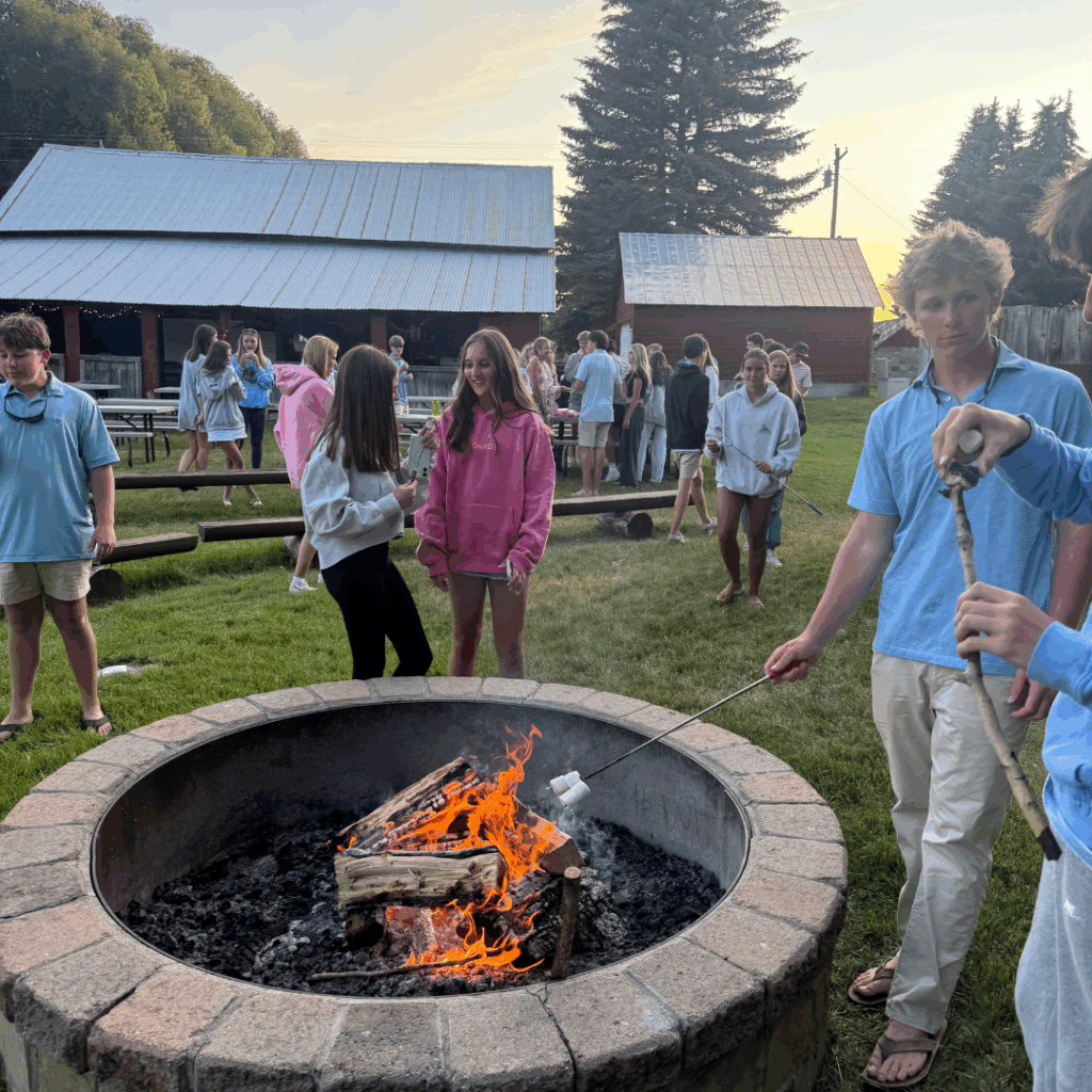 students roasting smores over a bonfire