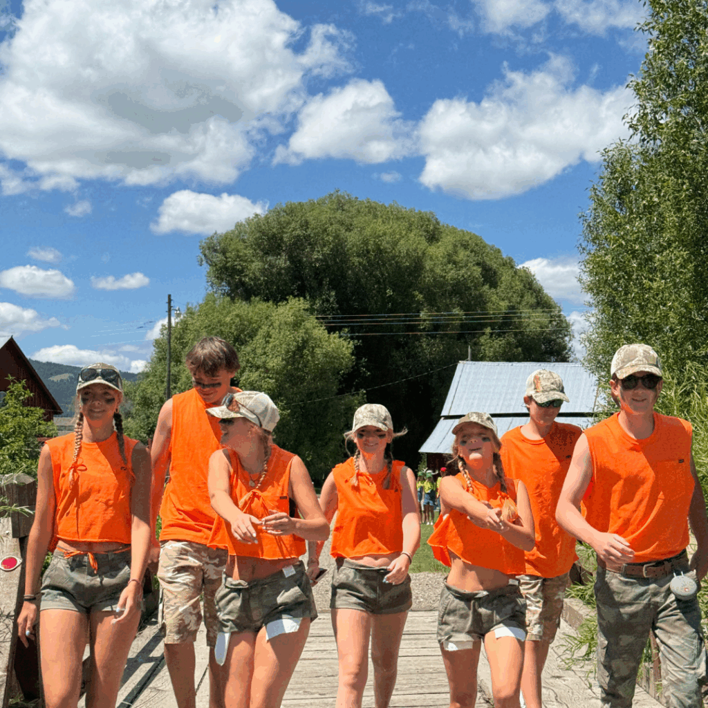 students in orange matching shirts walking toward camera 