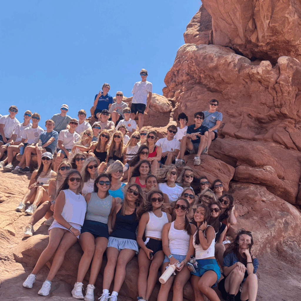 students posing at a rock in arches national park
