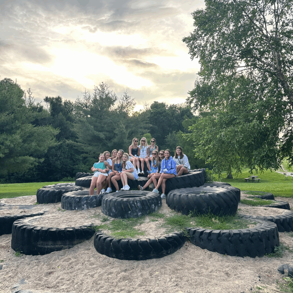 Girls posing on the tire pile during orientation 