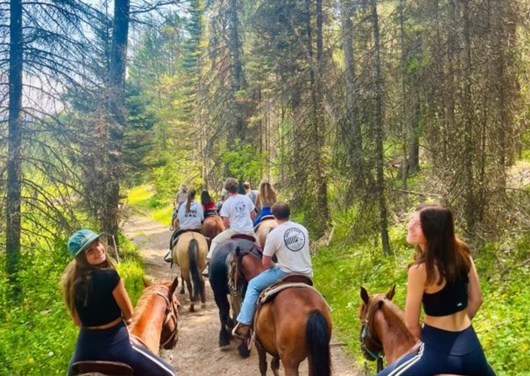 two students looking back during horseback riding