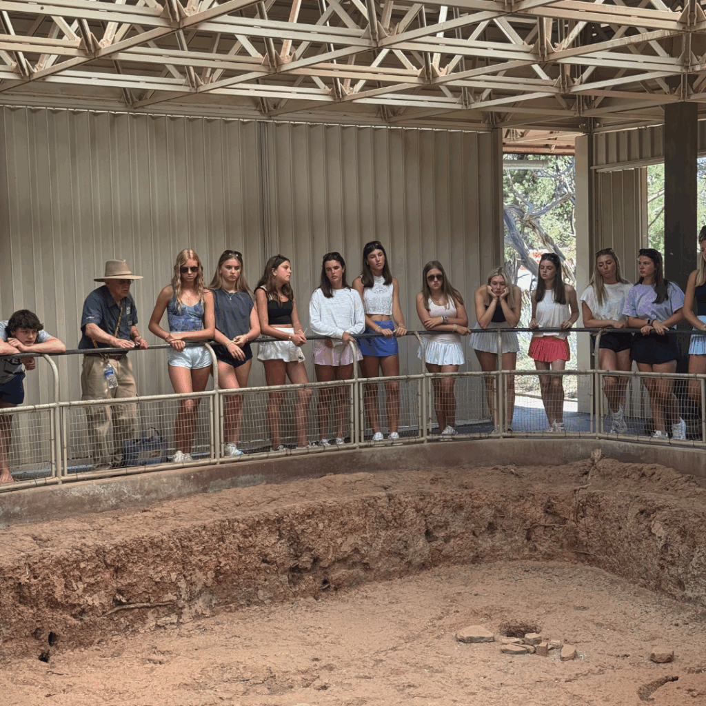 students receiving a lecture on the pit and standing at the railing