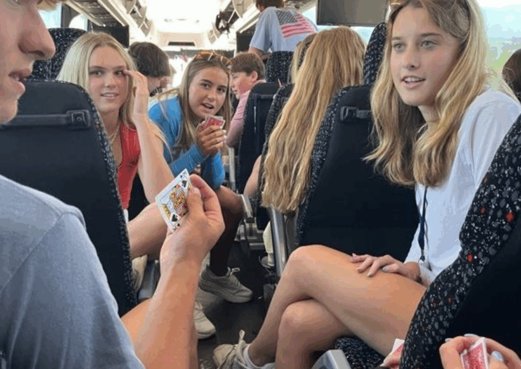 students playing card games on the bus