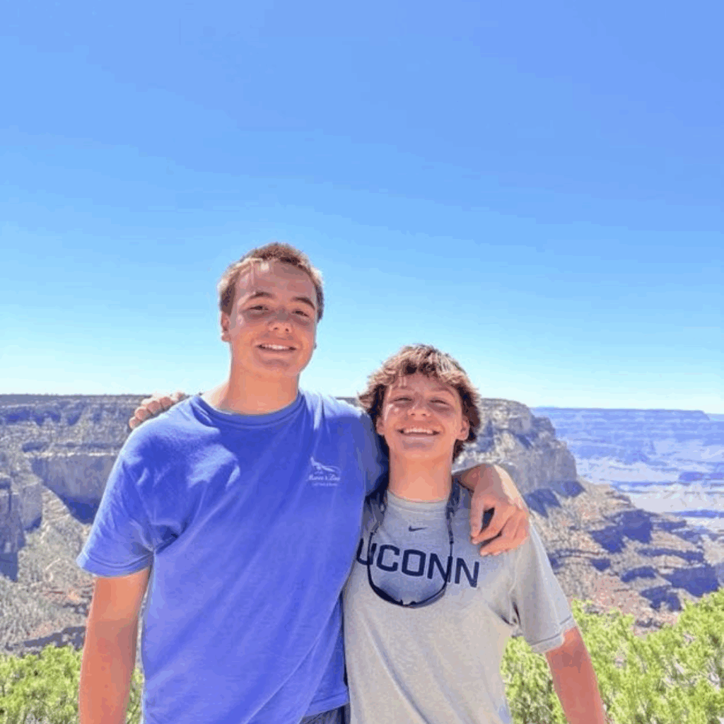 two friends linking arms at the grand canyon