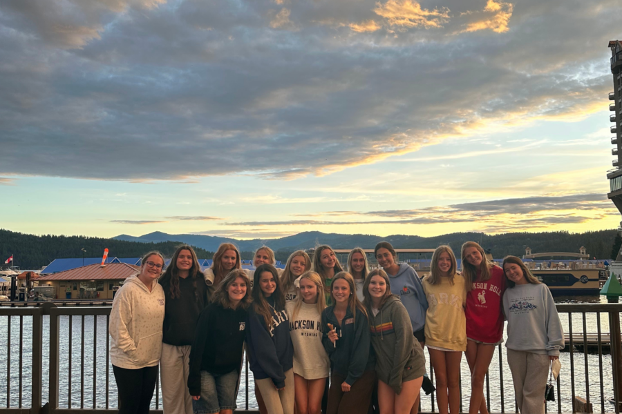 students in a line on the waterfront with a cloudy sunset