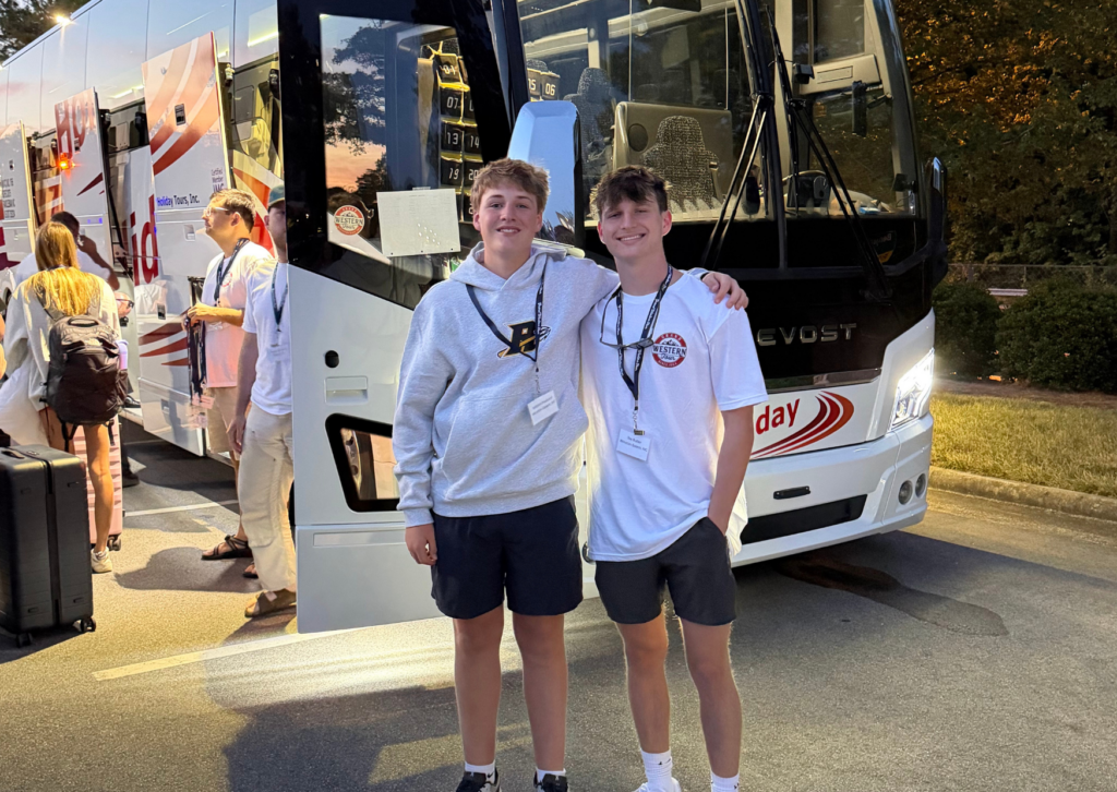 two students in front of bus