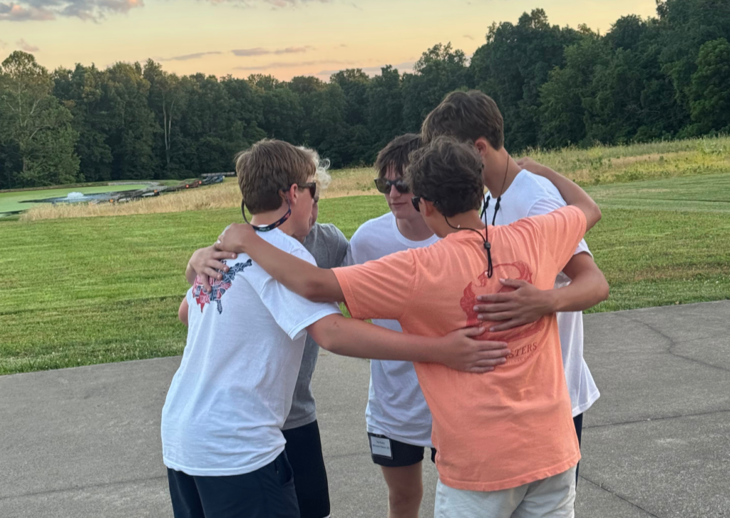 boys in a circle playing basketball 