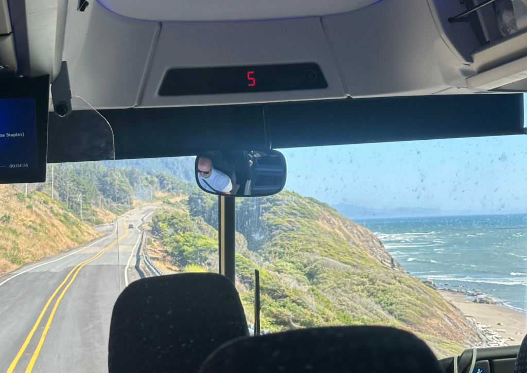 View from inside a vehicle driving along the Oregon Pacific Coast Highway with ocean and coastal cliffs visible