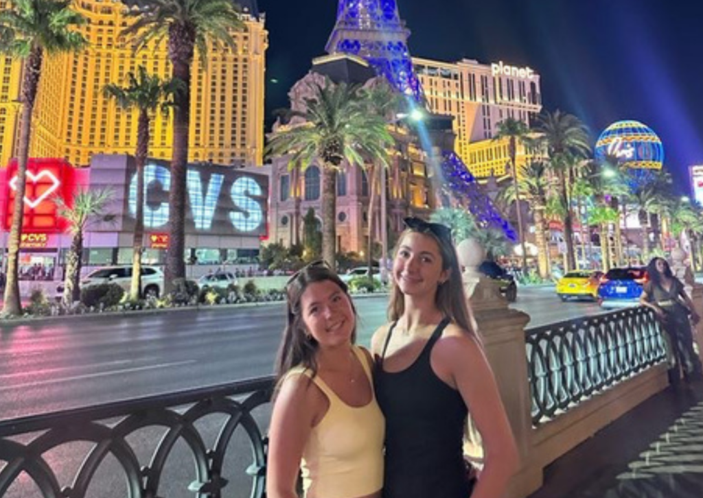 two female students hugging in front of the eiffel tower replica in las vegas