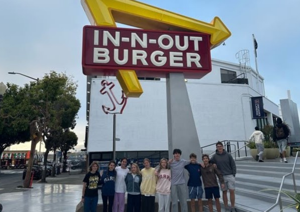 Group of teenagers posing outdoors under a large In-N-Out Burger sign