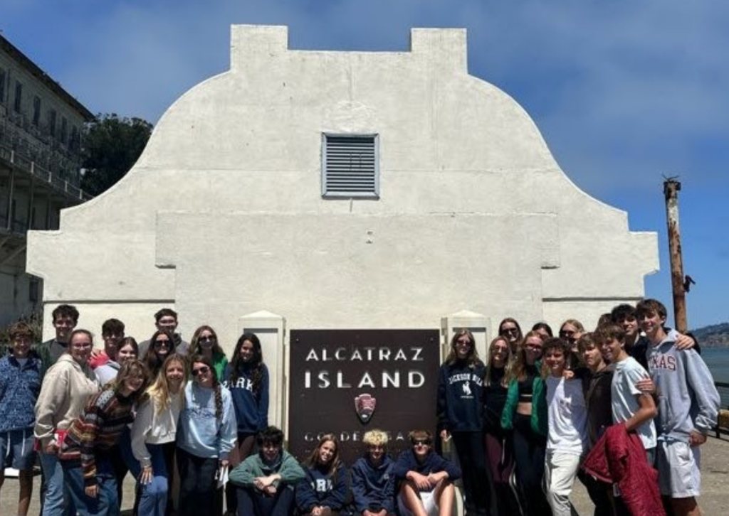 alcatraz island sign and building with students standing on either side