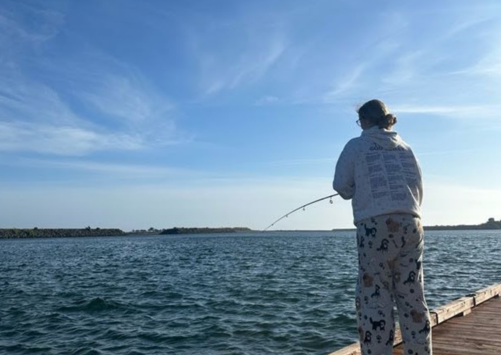 meg fishing in a gray sweatshirt off the dock in oregon