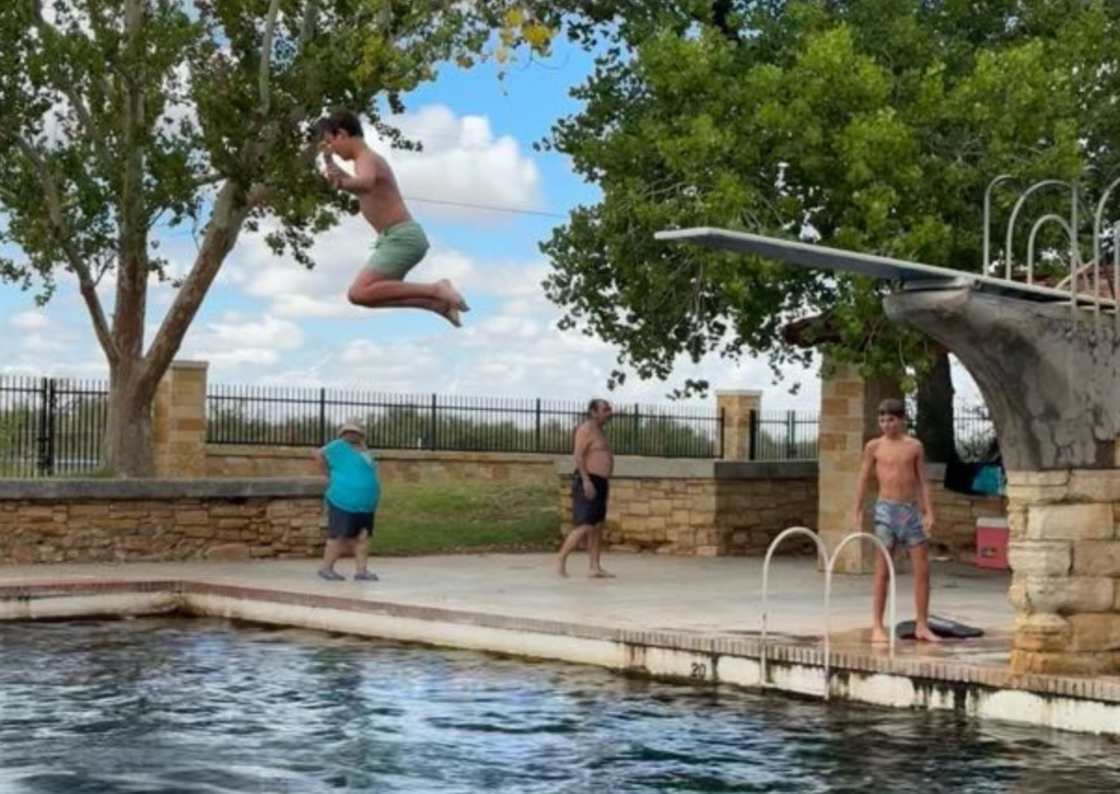 student jumping into the pool 