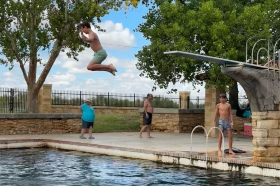 student jumping into the pool