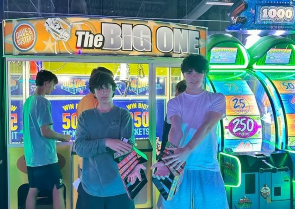 Two people playing a ticket redemption arcade game called The Big One at Dave & Buster's.
