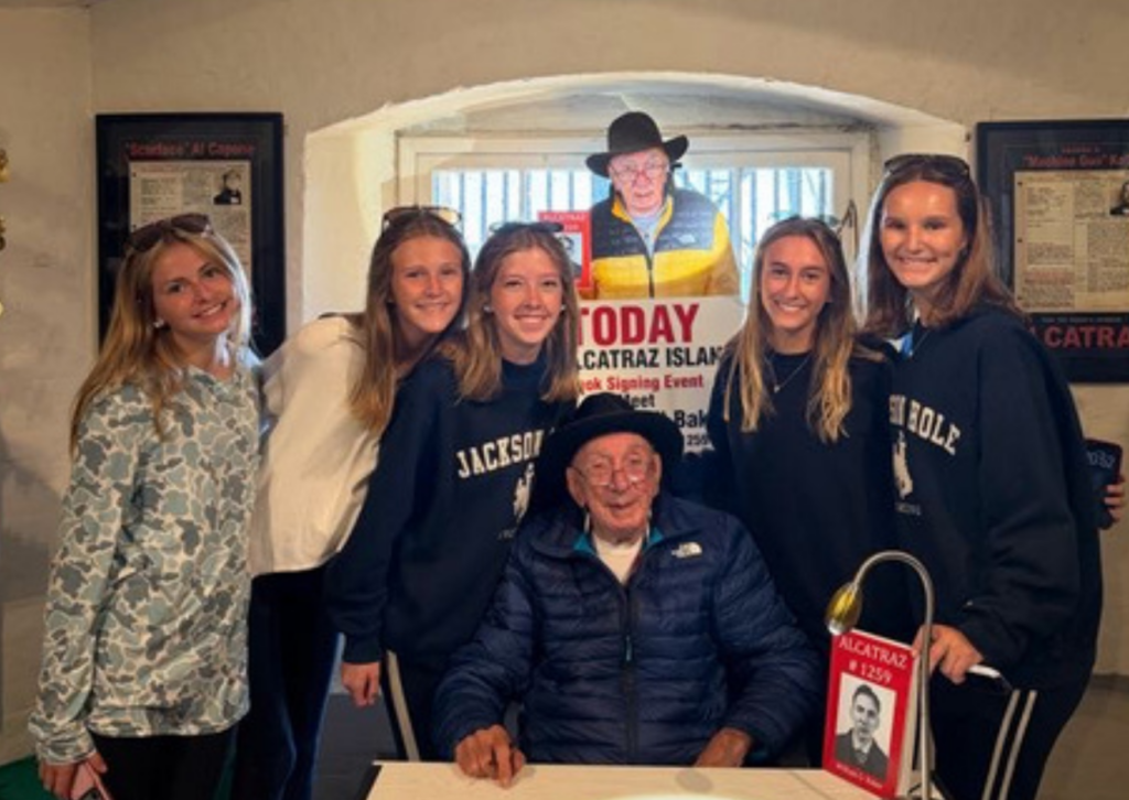 students around an older gentleman with book and table at alcatraz
