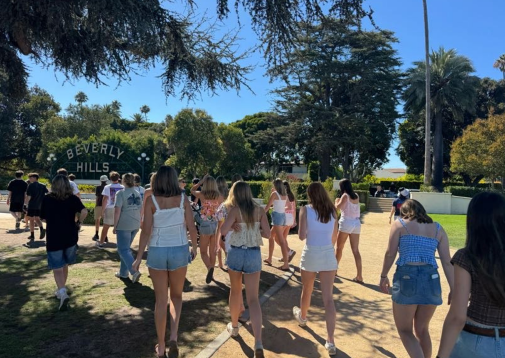 Group of friends walking through a park toward the Beverly Hills sign