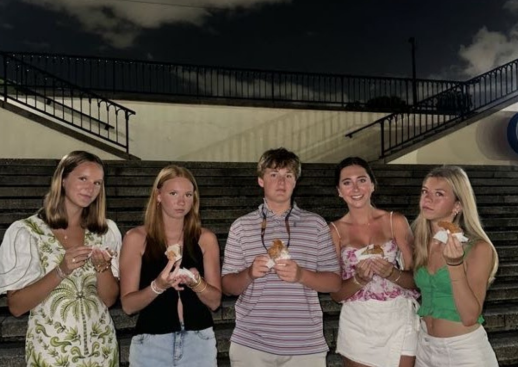 students on a step in new orleans with sandwiches