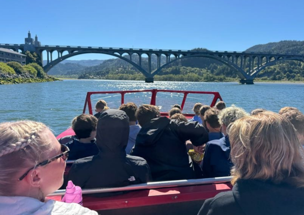 studnets looking at bridge and coastal sights from within the jet boat in oregon