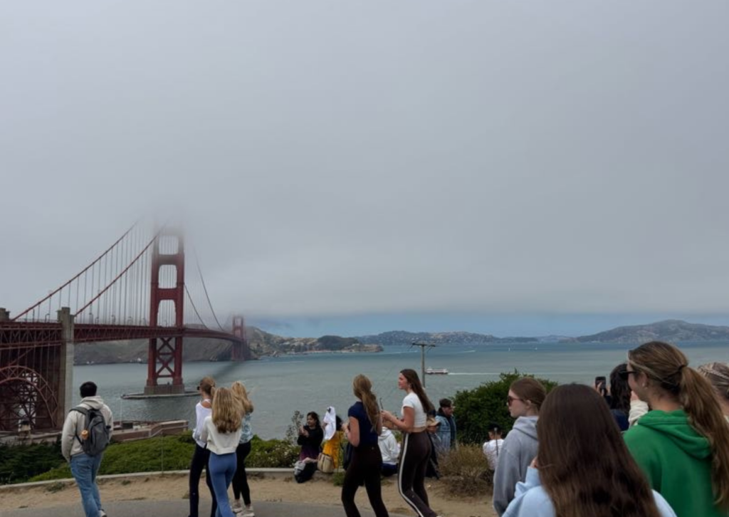 golden gate bridge in fog with students walking in front of it